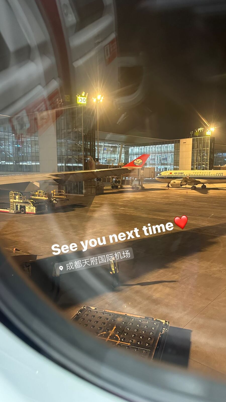 夜の空港、窓の向こうに並ぶ飛行機