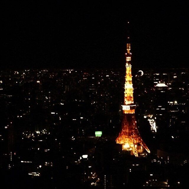 夜の街の中に立つ、赤く光る東京タワー