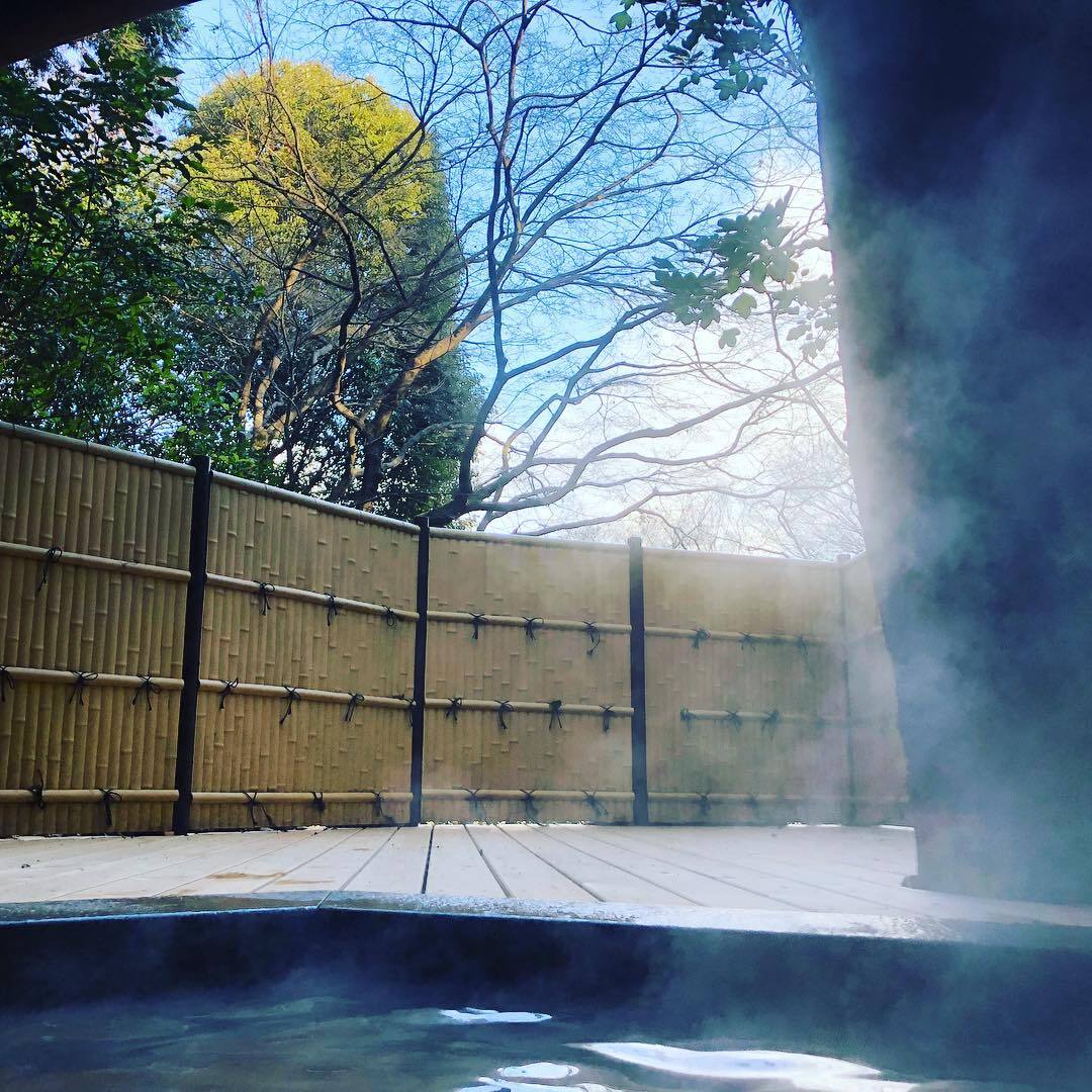 竹垣にかこまれた、湯気の立つ露天風呂