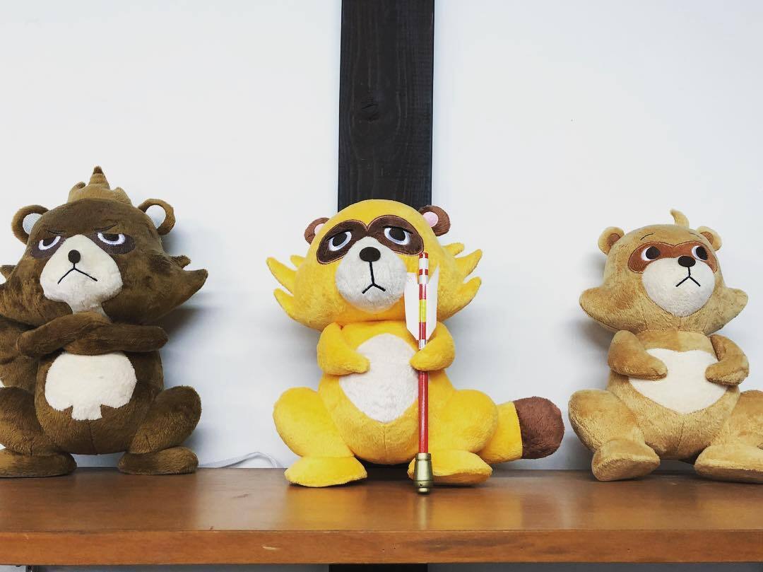 黄色い狸のぬいぐるみと、うしろの狸たち