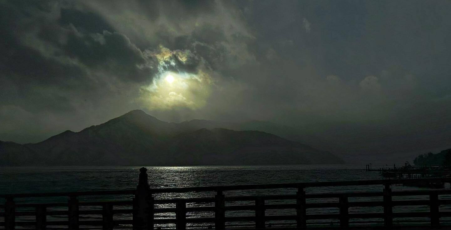 雲の切れ間から光がこぼれる、夕方の中禅寺湖