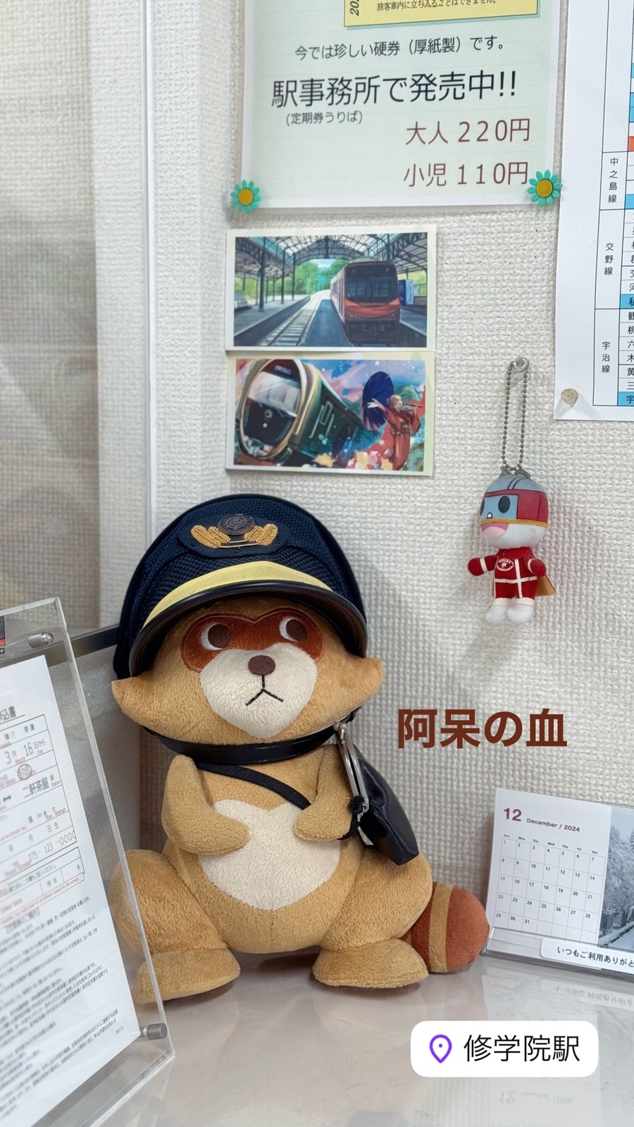駅長の帽子をかぶった狸のぬいぐるみ
