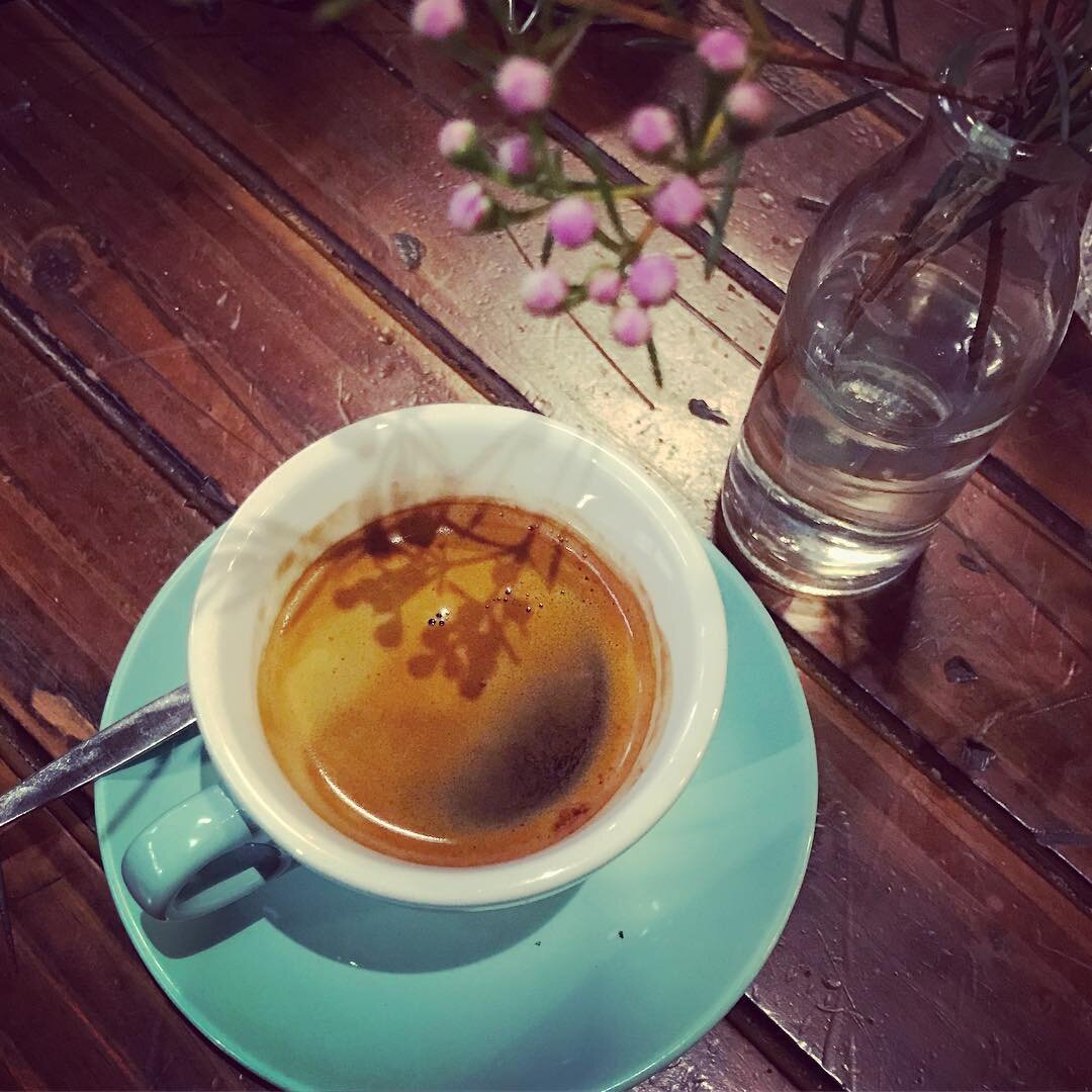 花の枝の横のコーヒー