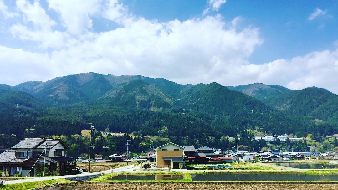 青い山並みと、ふもとの家