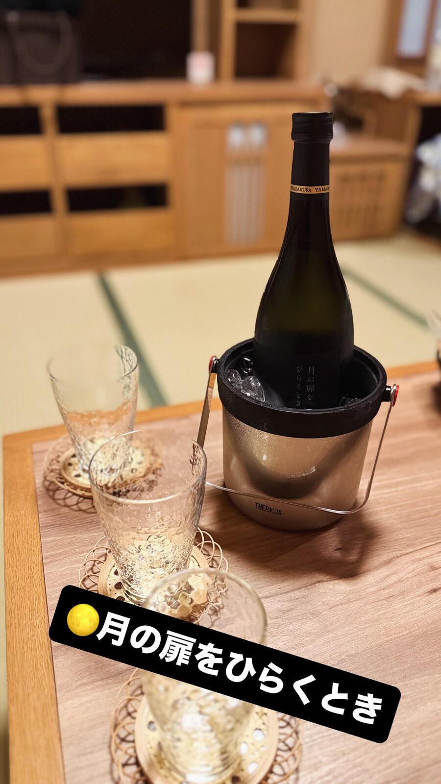 畳の部屋の座卓に、冷やした日本酒の瓶とグラス
