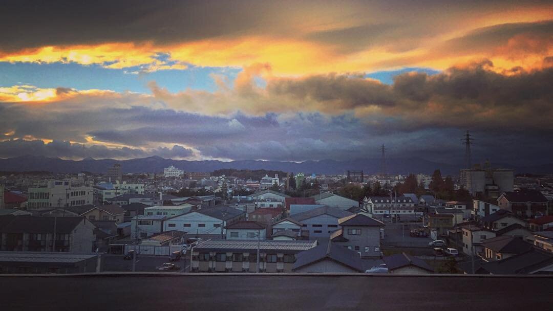 雲のすきまから光がさす、夕方の町