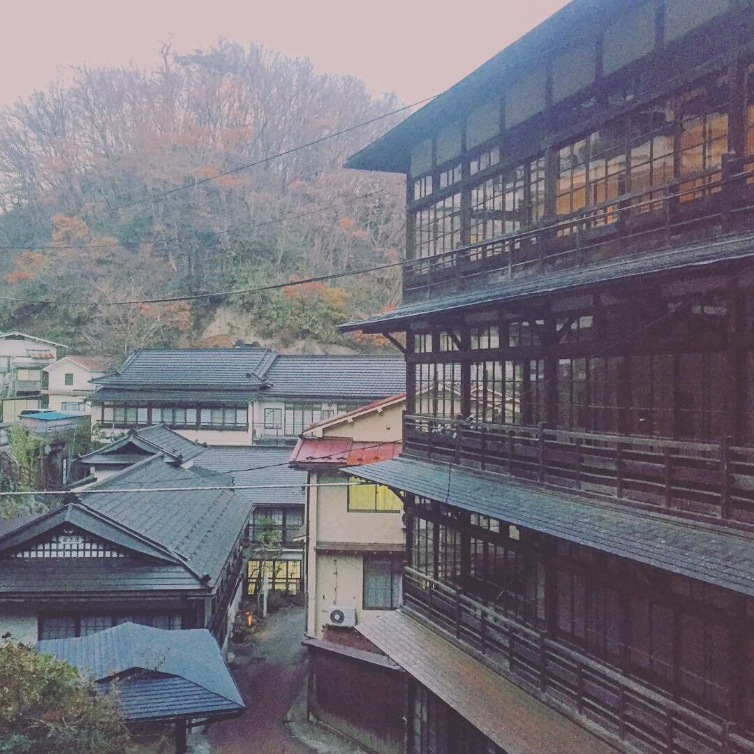 谷あいにかさなる旅館の瓦屋根