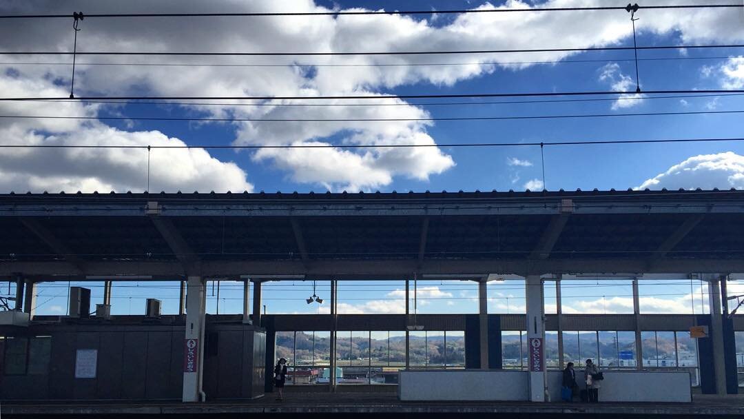 青空と雲の下の、駅のホーム