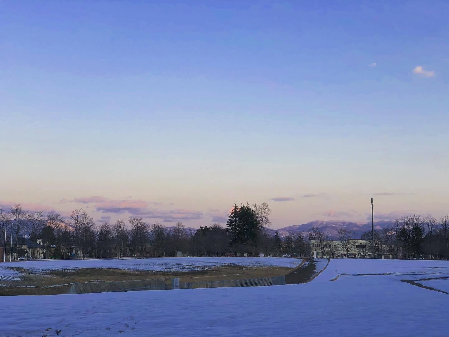 雪の野原の向こうの、夕暮れの空