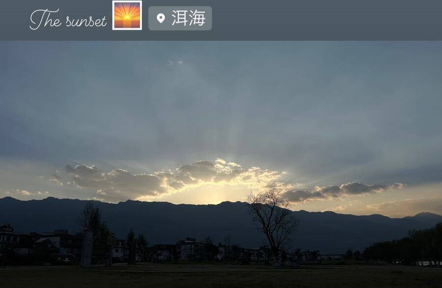 山の向こうに沈む夕日と、光の筋