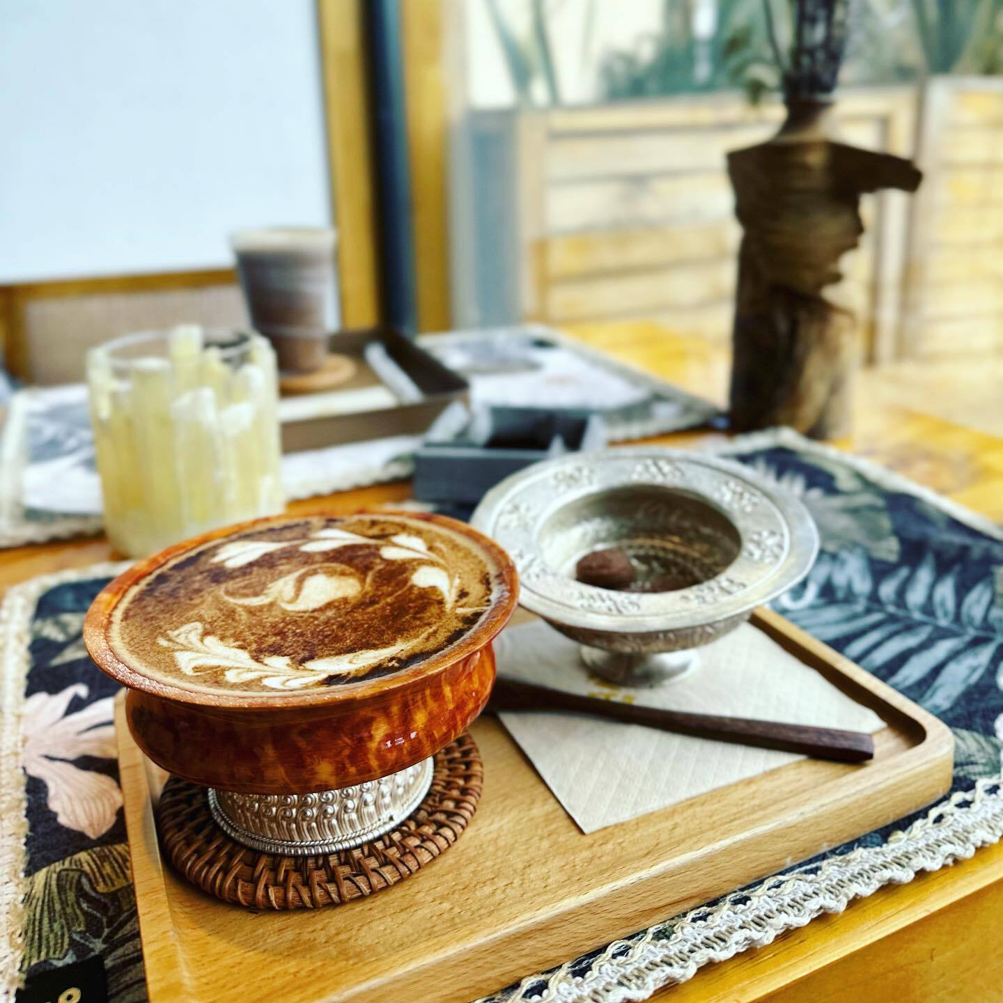 木の器に入った、ラテアートのヤクミルクコーヒー